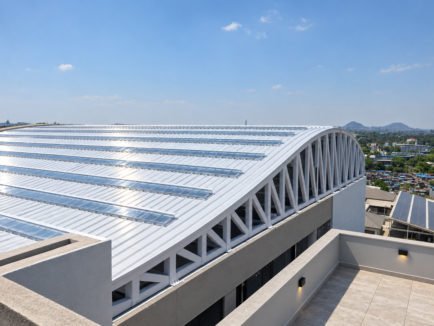 Curved metal roof with white steel trusses